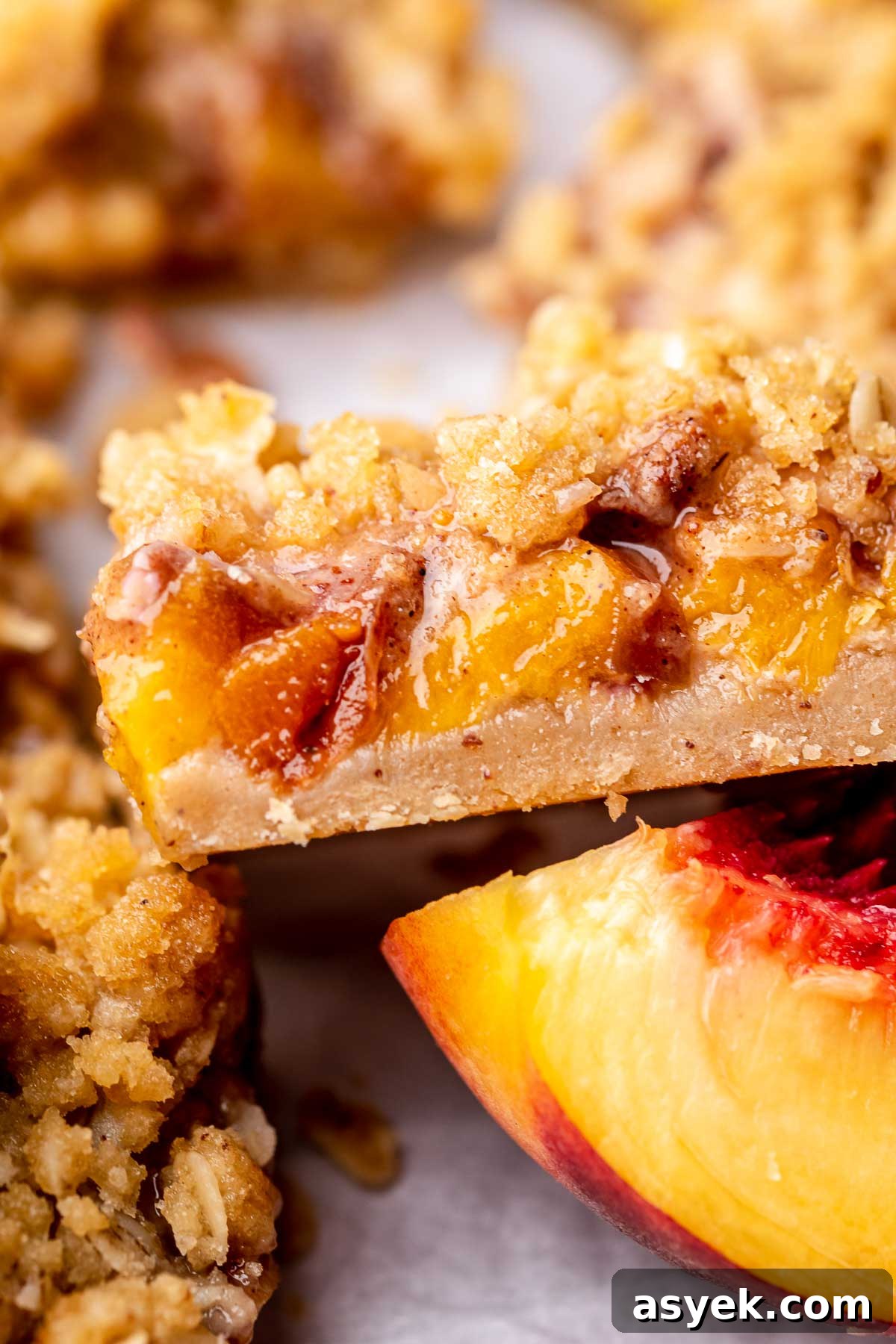 Brown Butter Peach Crumble Bars Recipe 13 A slice of peach crumble bars sliced laying on its side.