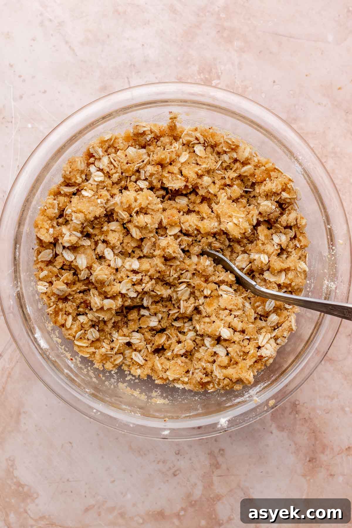 Brown Butter Peach Crumble Bars Recipe 9 A fork mixes streusel crumbles in a bowl.