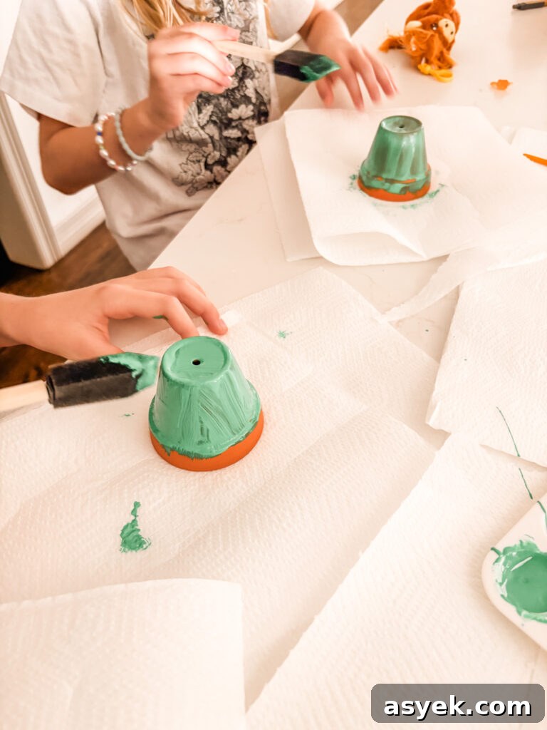DIY Clay Pot Christmas Ornaments: Holiday Decor Project 5 Painting the entire clay pot green