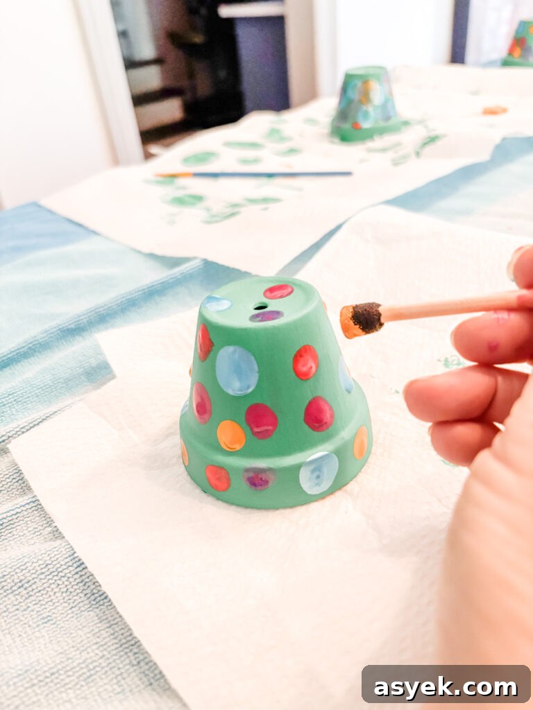 DIY Clay Pot Christmas Ornaments: Holiday Decor Project 6 Marie using a stipple brush to paint ornaments