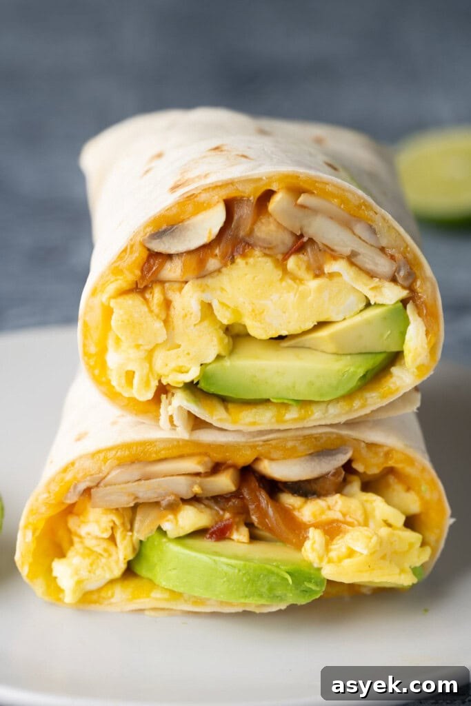 Vegetarian Breakfast Burrito Recipe with Avocado and Fresh Salsa 2 Two halves of a meatless breakfast burrito stacked on top of each other.