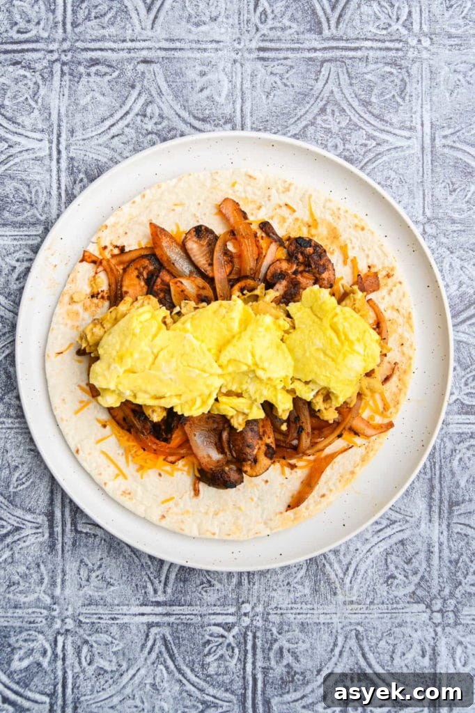 Vegetarian Breakfast Burrito Recipe with Avocado and Fresh Salsa 8 Adding scrambled egg to vegetarian breakfast burrito.