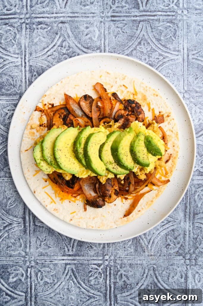 Vegetarian Breakfast Burrito Recipe with Avocado and Fresh Salsa 9 Adding sliced avocado to vegetarian breakfast burrito.