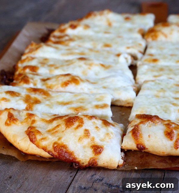Crispy Gluten-Free Garlic Pizza Breadsticks Recipe 4 A slice of pizza sitting on top of a wooden cutting board cut into breadsticks
