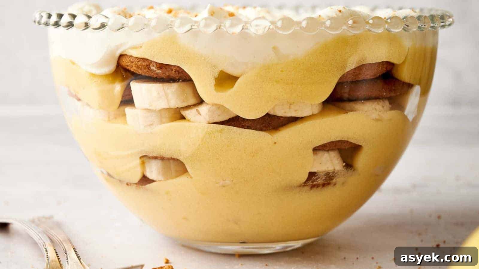 Banana pudding in a bowl with whipped cream and bananas.
