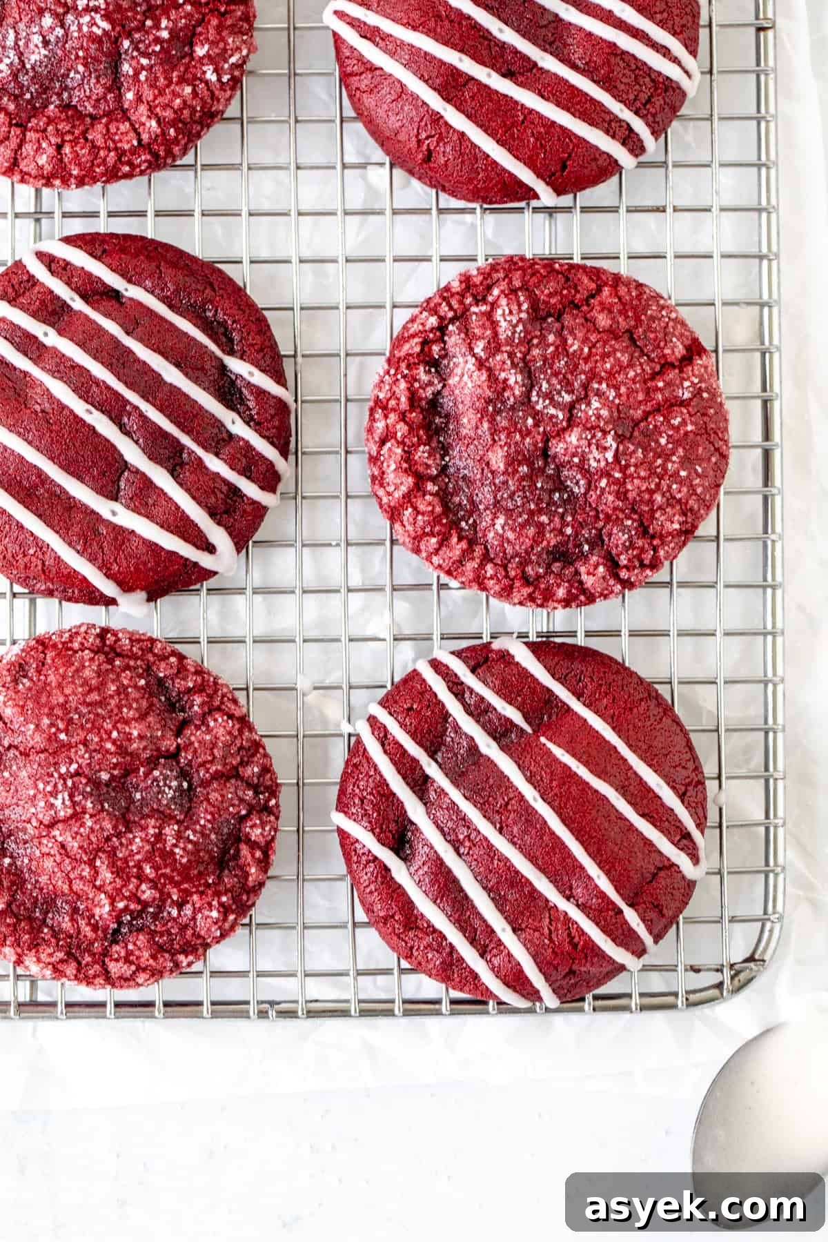 Red Velvet Cookies with Cream Cheese Filling 3 Red velvet cookies on a cooling rack, some cookies drizzled with glaze and some rolled in sugar