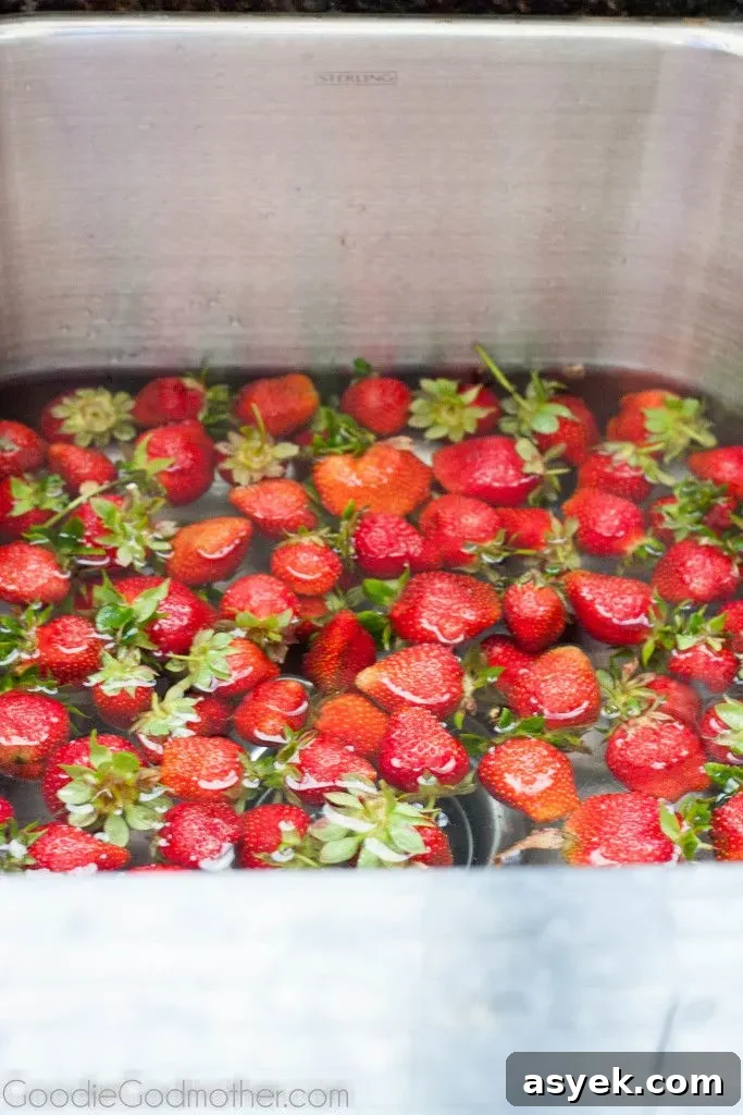 Washing strawberries in a bowl of vinegar and water