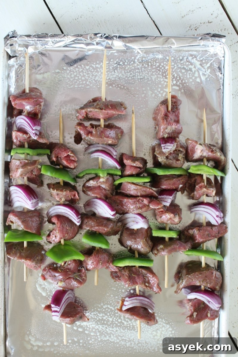 Lamb skewers ready for broiling skewers of lamb souvlaki on baking sheet ready for broiling