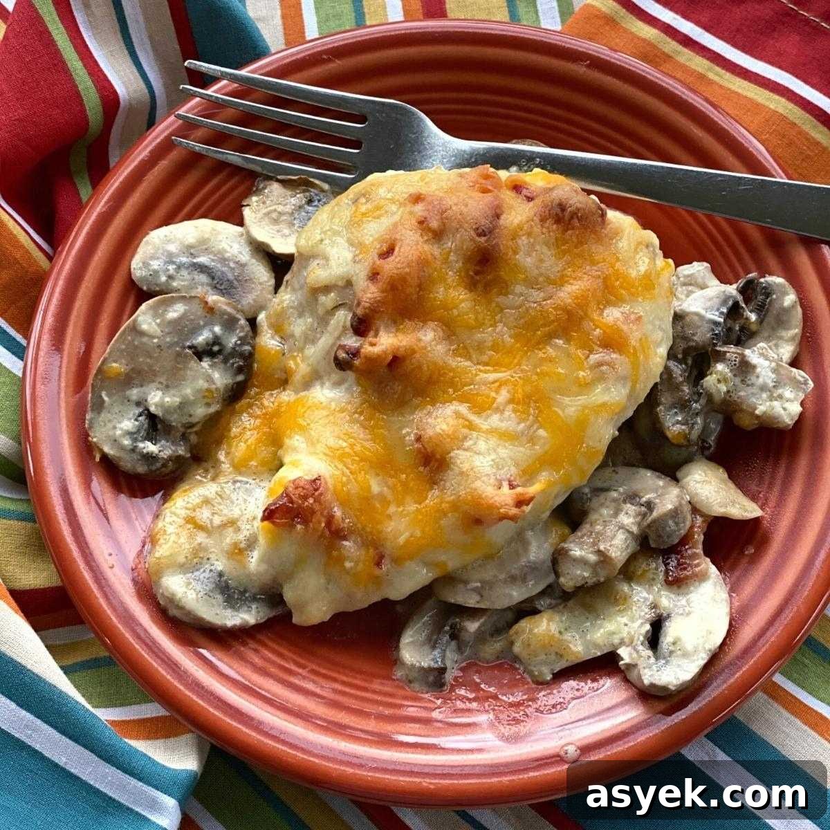 Alice Springs Chicken topped with honey mustard and cheese on plate with mushrooms surrounding it.