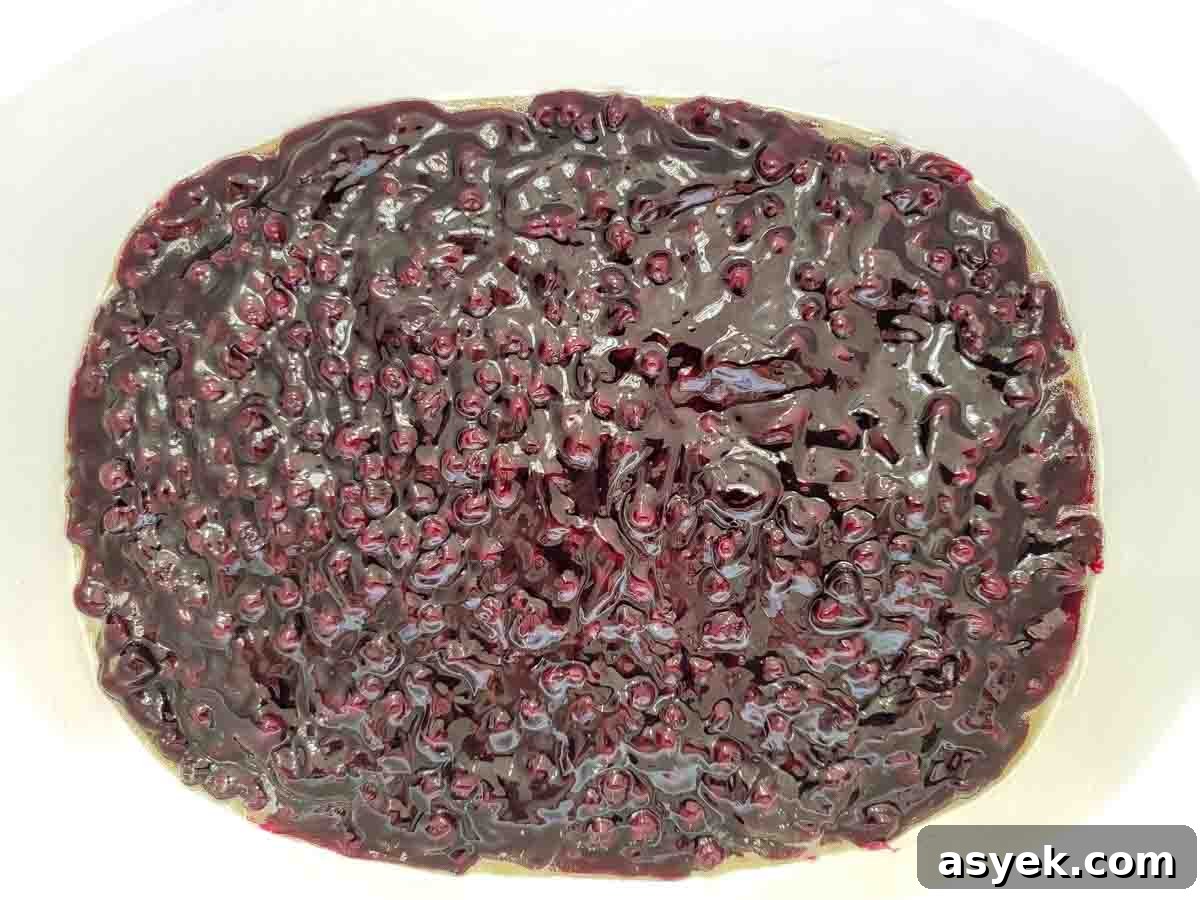 Zesty Lemon Cake with Blueberry Filling 3 blueberry pie filling in the bottom of a large dish.