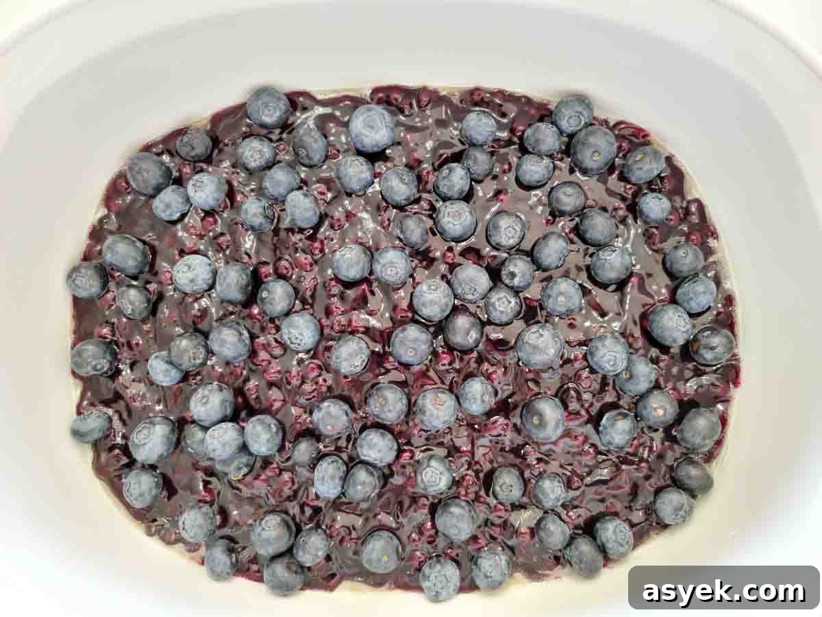 Zesty Lemon Cake with Blueberry Filling 4 fresh blueberries and pie filling in a large dish.