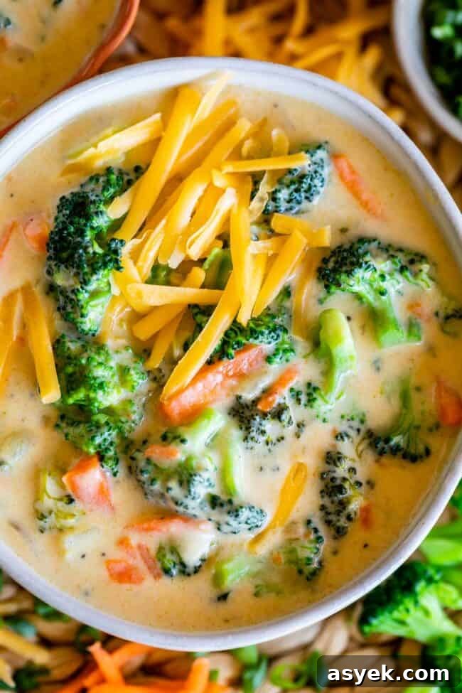 broccoli and cheese soup in a bowl with cheese sprinkled on top.
