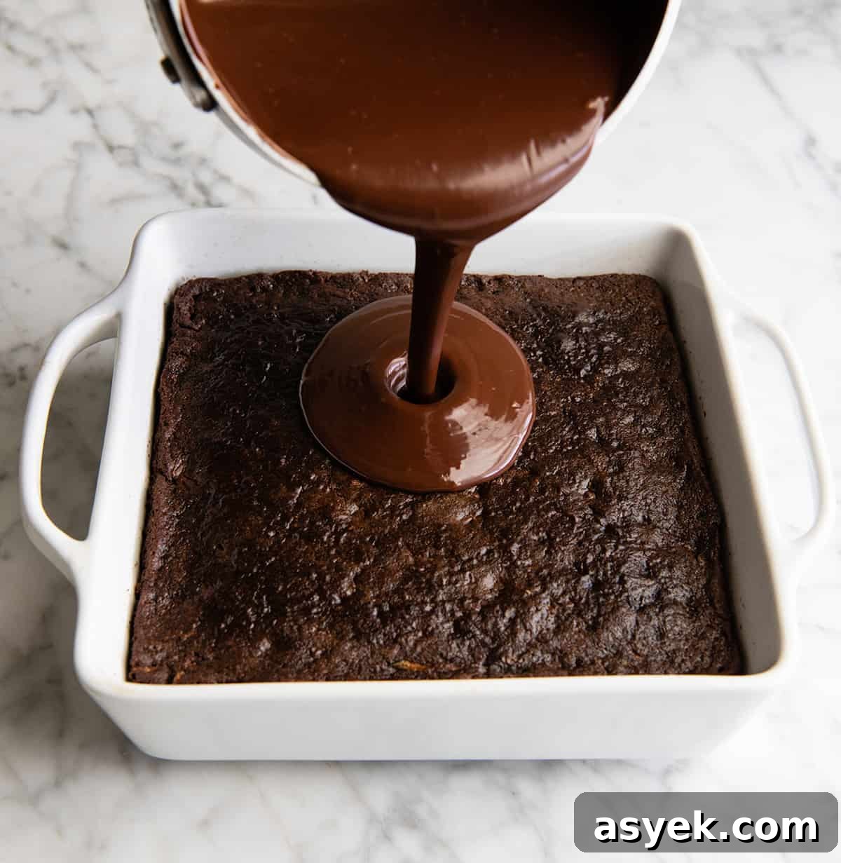 Moist Chocolate Zucchini Cake Recipe 8 front view of chocolate ganache being poured onto the baked chocolate zucchini cake
