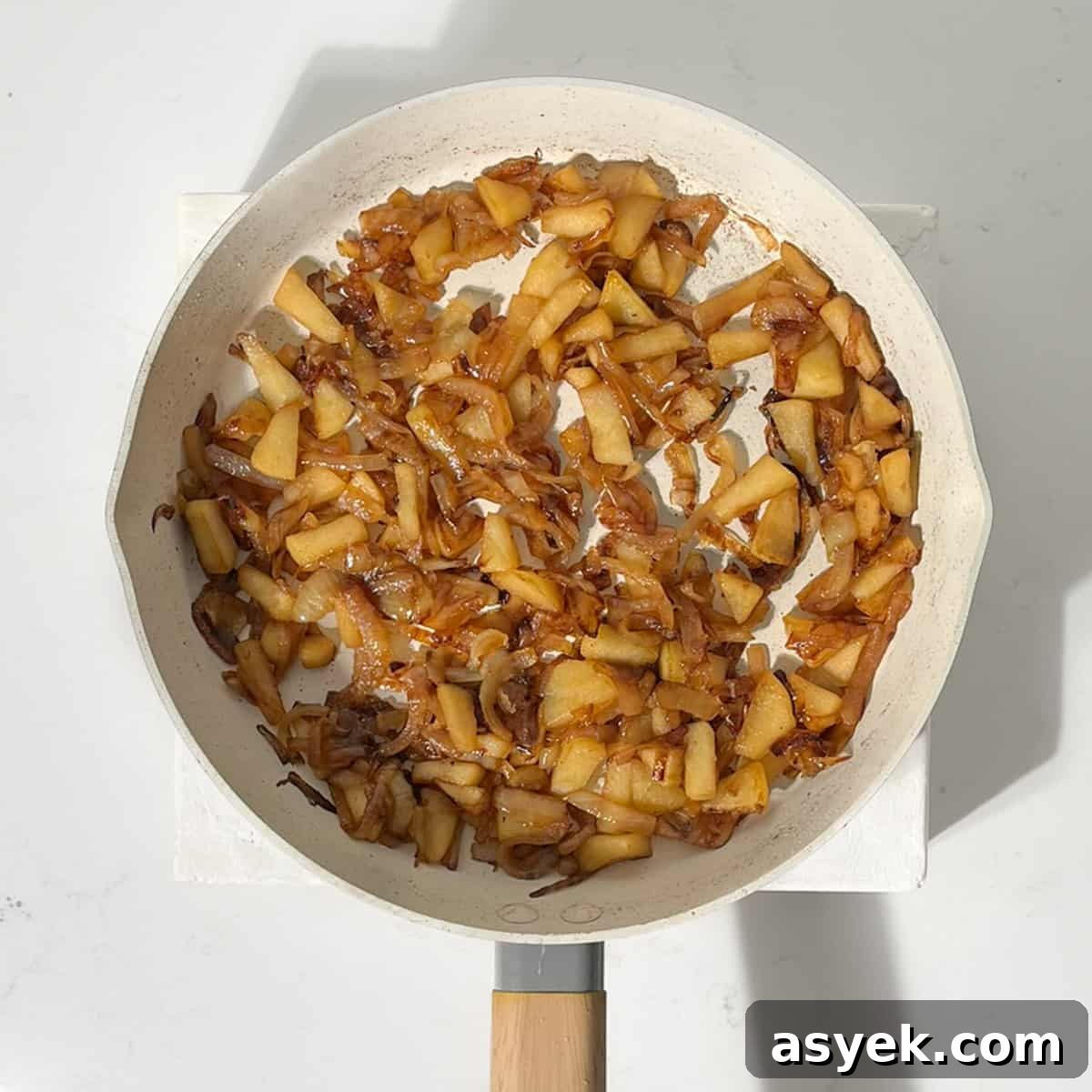 Caramelised apples and onions in a large frying pan.