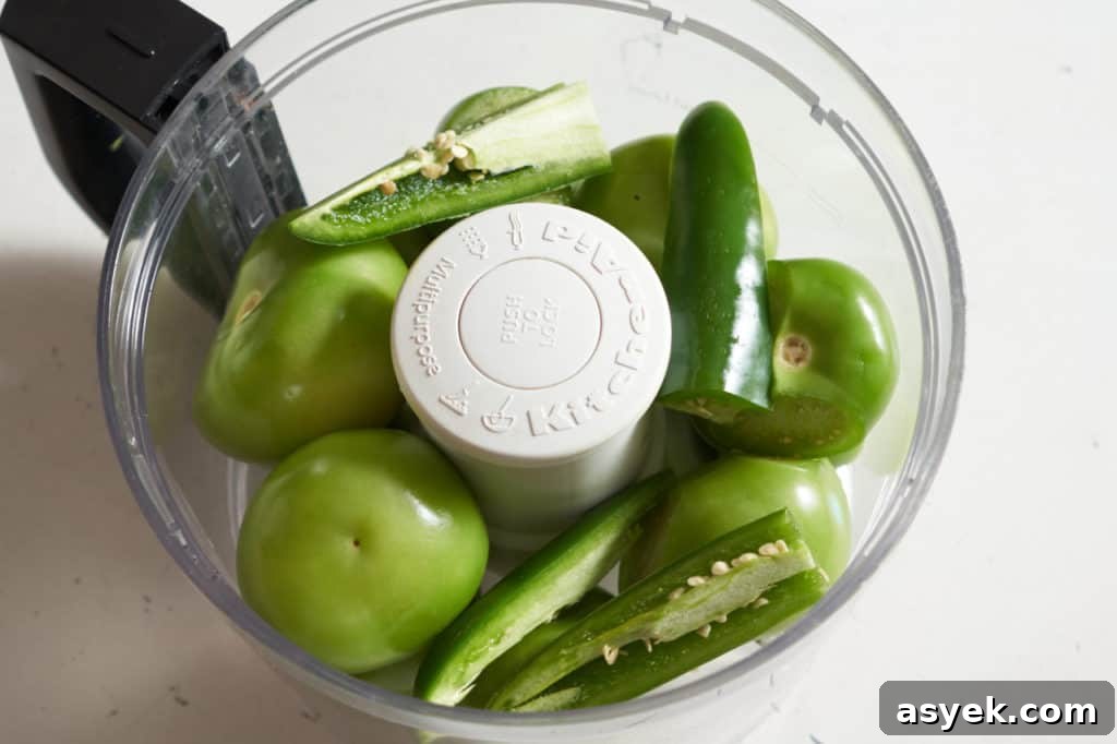 Tomatillos and jalapeño peppers in a food processor.