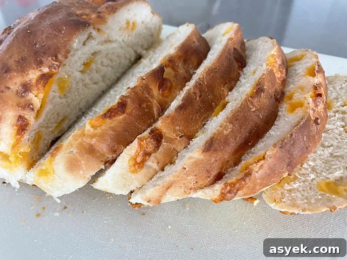 Cheesy Pull-Apart Bread Recipe 3 A loaf of Easy Cheesy Bread with five slices stacked diagonally on each other.