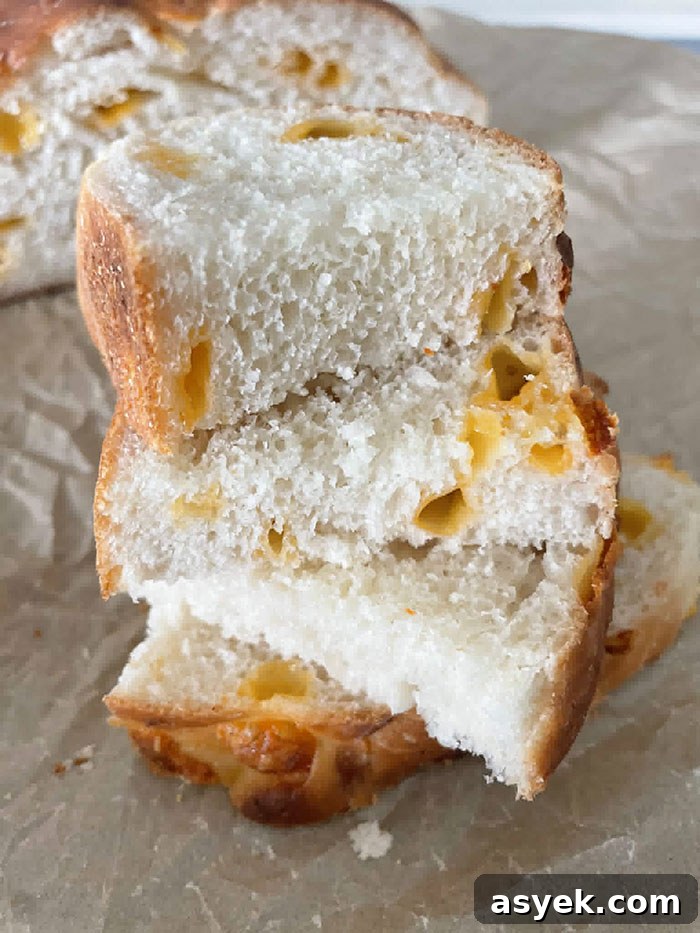 Three slices of Easy Cheesy Bread stacked offset on each other on parchment paper.