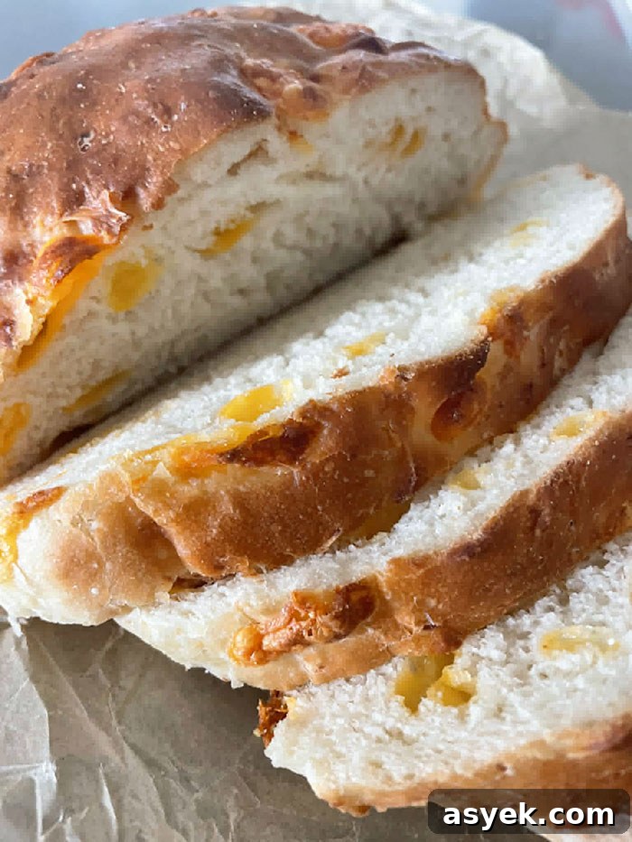 A loaf of Easy Cheesy Bread with a few cut slices.