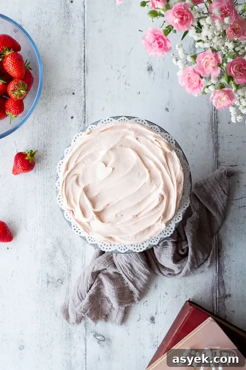 Top down view of a freshly frosted strawberry cake