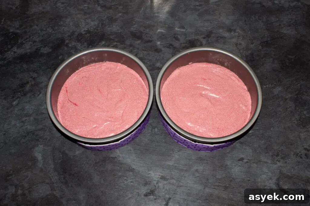 Strawberry cake batter in two round cake tins.