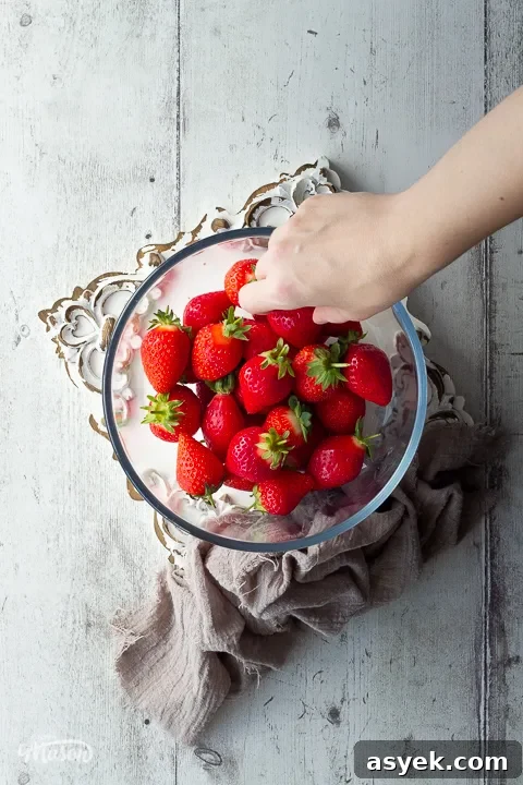 Someone picking a strawberry from a bowl