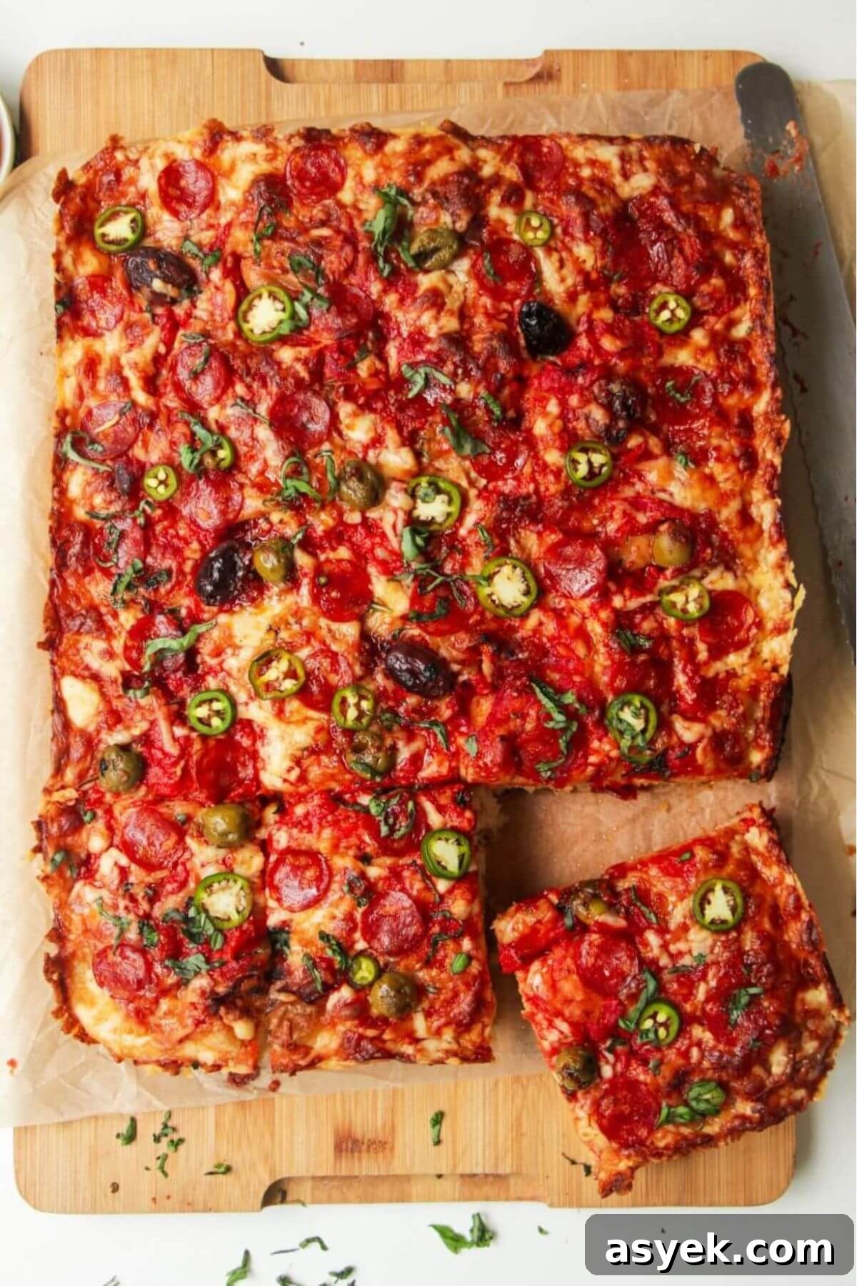 Pepperoni Focaccia Pizza Bread with Crispy Cheese Crust 2 Focaccia pizza bread, sliced on a large wooden board.