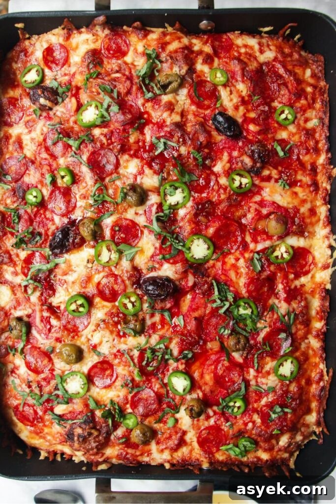 Pepperoni Focaccia Pizza Bread with Crispy Cheese Crust 13 Jalapenos and sweet chilli drizzled on top of baked focaccia pizza in a large oven tray.