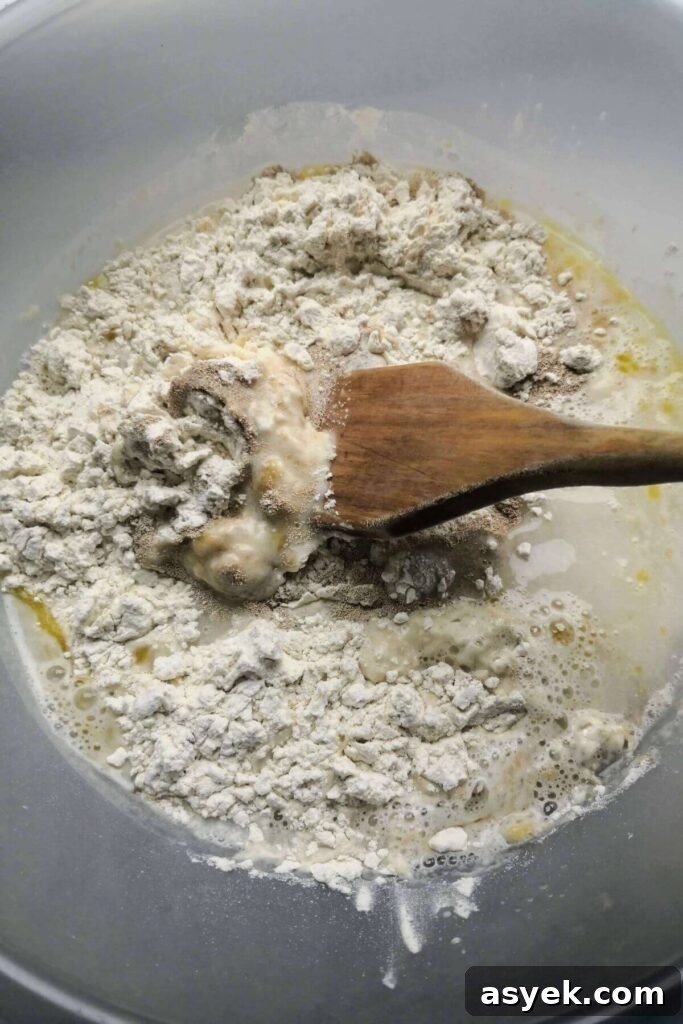 Pepperoni Focaccia Pizza Bread with Crispy Cheese Crust 4 Foccacia dough about to be mixed in a large clear bowl with a wooden spoon