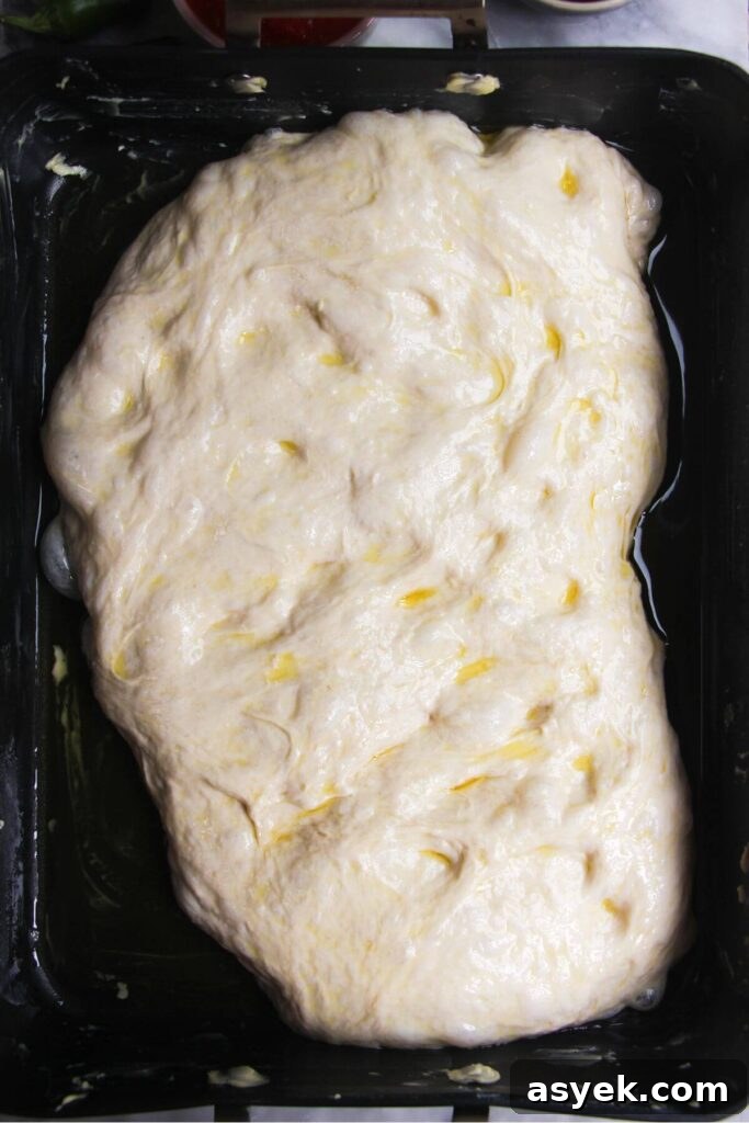 Pepperoni Focaccia Pizza Bread with Crispy Cheese Crust 6 Focaccia dough in a large oven tray.
