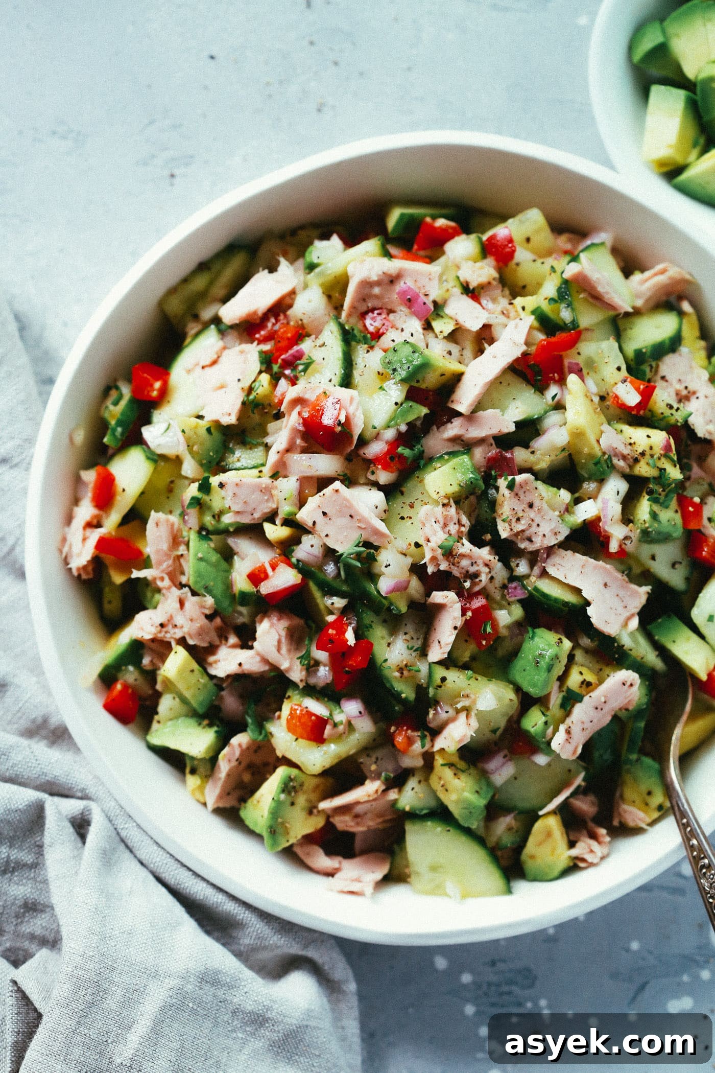Overhead photo of a white bowl of avocado tuna salad. 