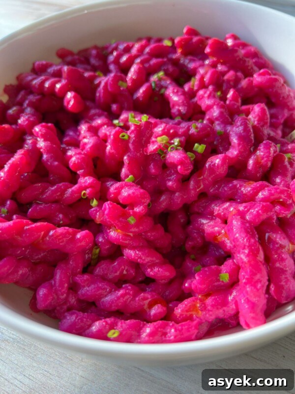 A white bowl filled with vibrant Barbie Pasta