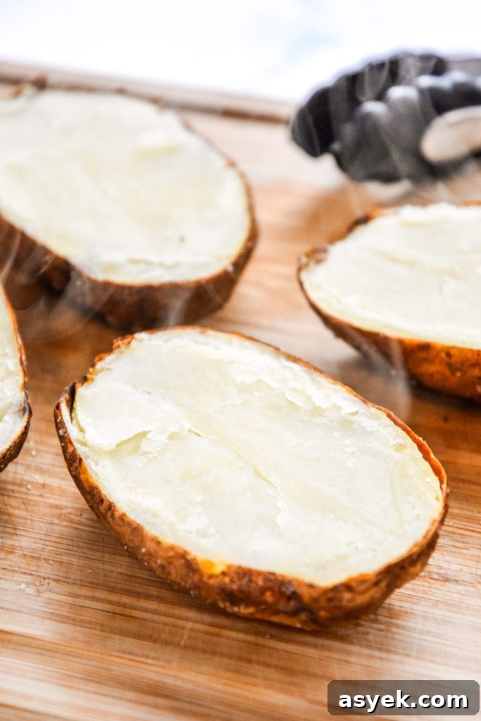 baked potatoes sliced in half on a cutting board.