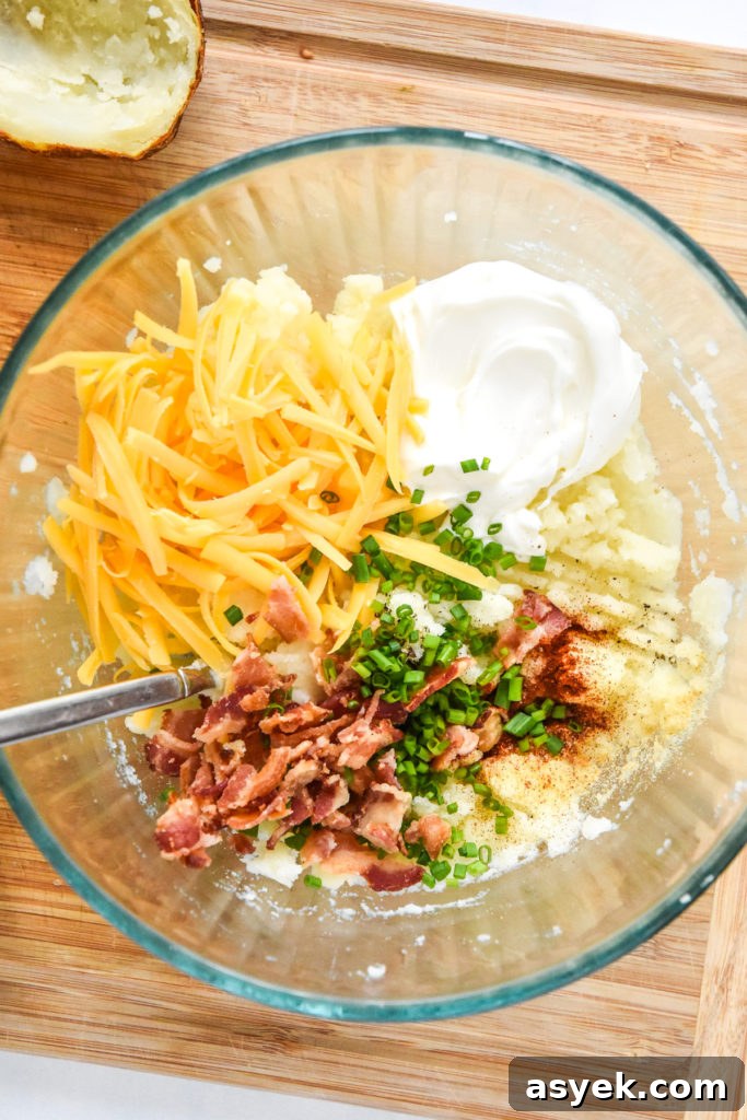 filling with cheese and bacon in a glass bowl for air fryer twice baked potatoes.