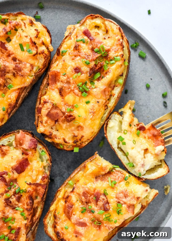 cooked air fryer twice baked potatoes with one sliced open.