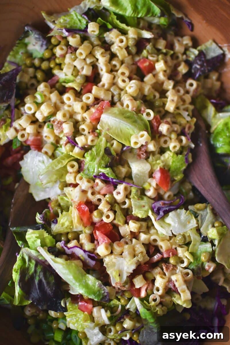 Tossing the salad together with all the toppings.