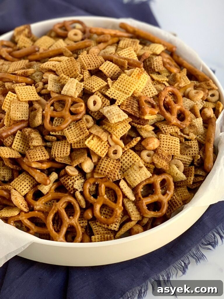 A large bowl of chex mix with pretzels, circle o cereal, chex mix, corn mix, and peanuts.