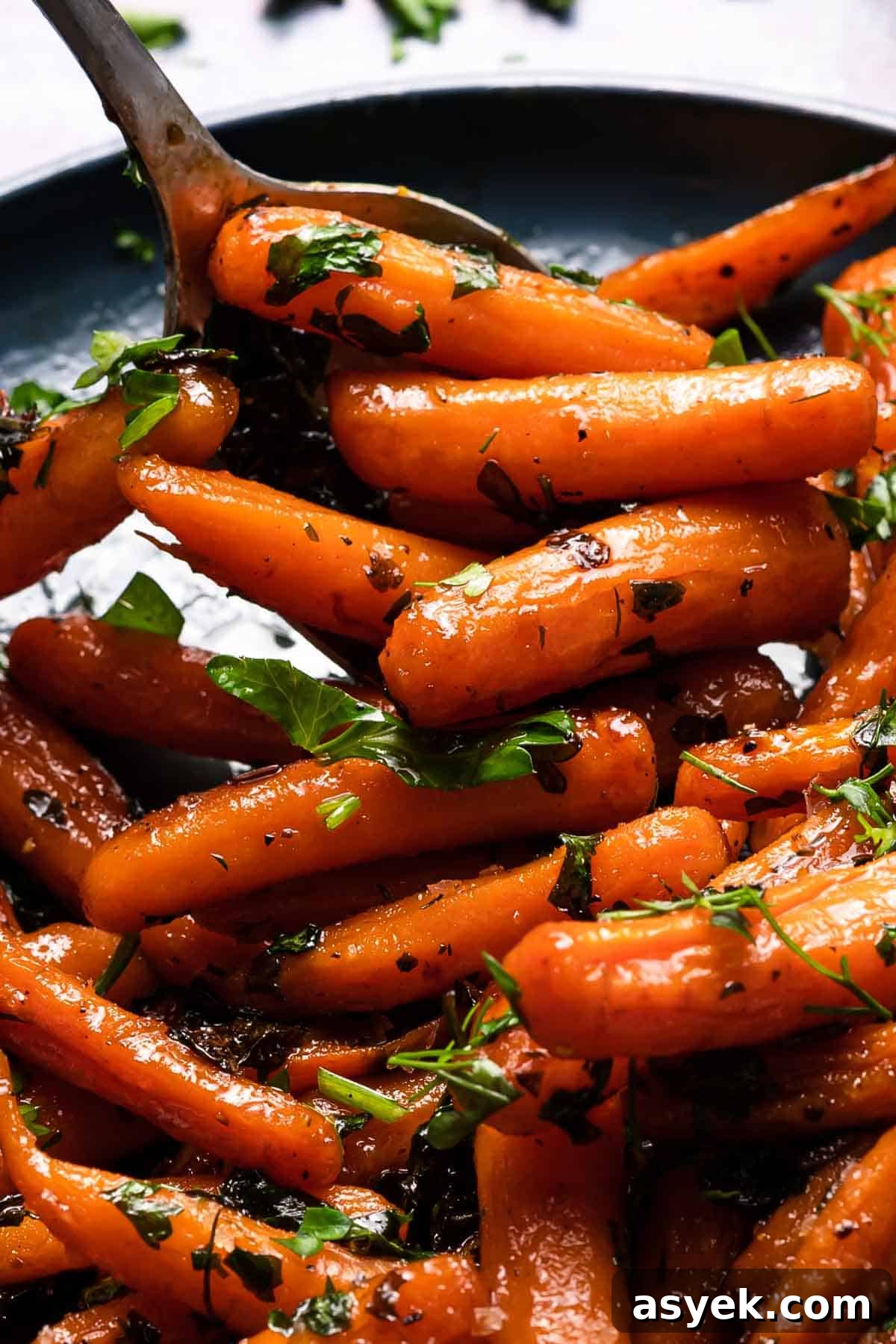 honey orange glazed carrots on plate with spoon