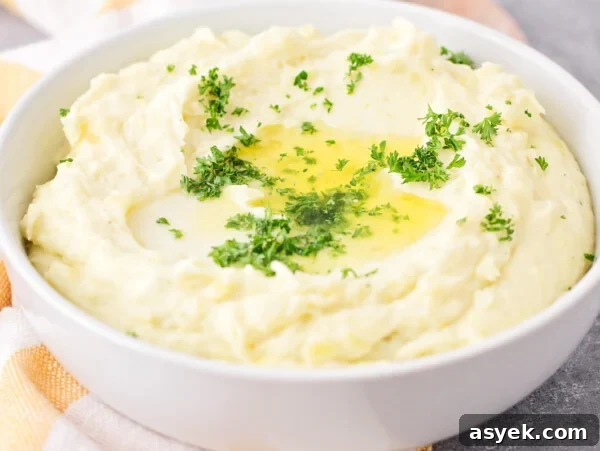 Close up image of make-ahead mashed potatoes recipe served in white bowl.