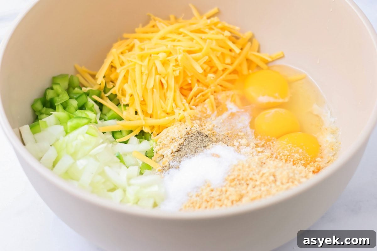 Eggs, cheese, veggies, and seasonings in a bowl.