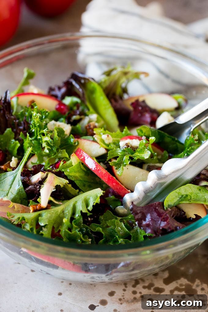 Tongs serving up a portion of Thanksgiving salad.