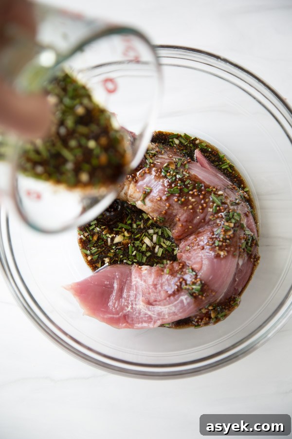 Balsamic Pork Loin Marinade for Grilling or Roasting 11 pouring balsamic pork loin marinate over pork tenderloin in a bowl