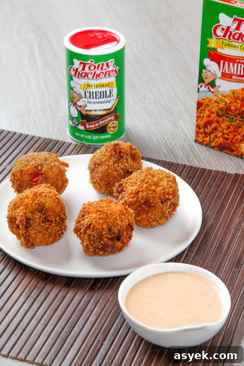 Crispy Deep-Fried Jambalaya Recipe 3 five deep fried jambalaya balls with a cajun dipping sauce on the side.