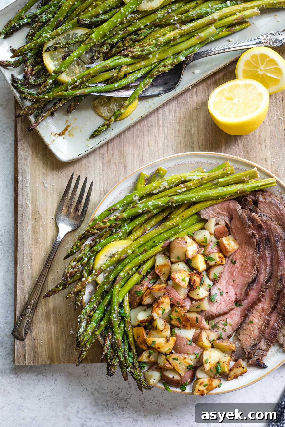 Grilled Asparagus Recipe with Parmesan, Lemon and Garlic 11 Plated dinner of grilled asparagus, potatoes and steak with serving platter of asparagus nearby.