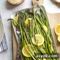 Grilled Asparagus Recipe with Parmesan, Lemon and Garlic 15 Asparagus after grilling, served on platter with lemon slices and sprinkling of parmesan.