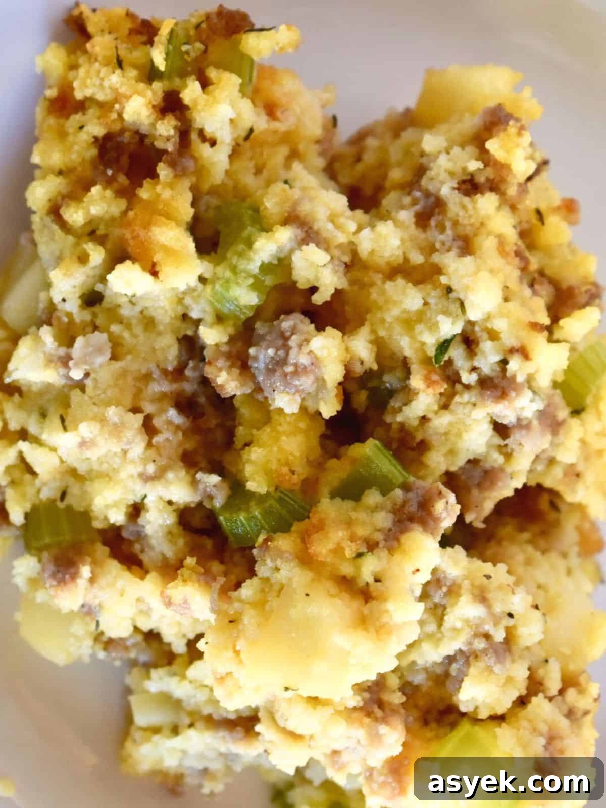Savory Cornbread Stuffing with Sausage and Apples 6 Fluffy cornbread stuffing with sausage and apples on a white plate.