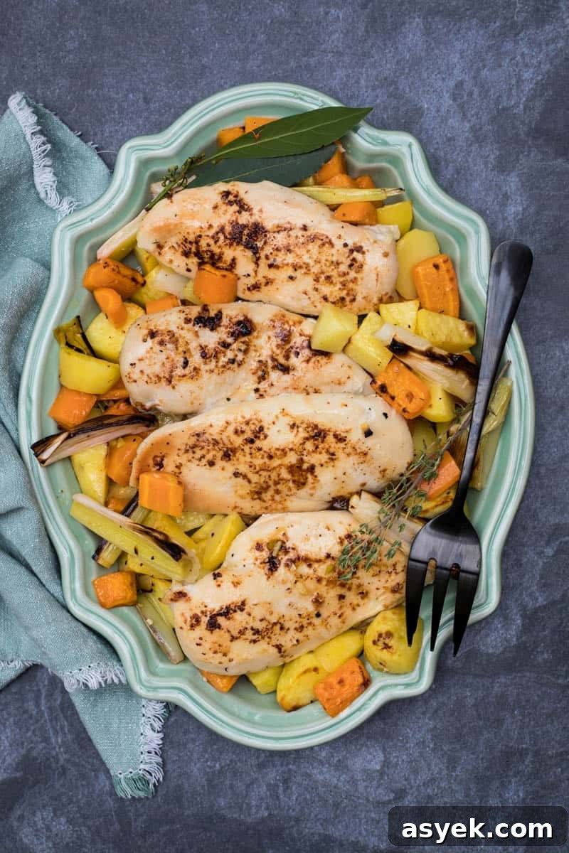Crispy Sheet Pan Chicken and Roasted Potatoes Recipe 2 sheet pan roasted chicken with potatoes, leeks, and carrots on serving dish with napkin and serving fork
