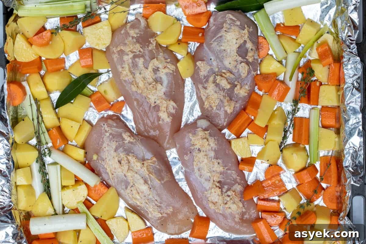 Crispy Sheet Pan Chicken and Roasted Potatoes Recipe 5 chicken breasts with spiced butter on foil lined sheet pan with potatoes, carrots, leeks and herbs