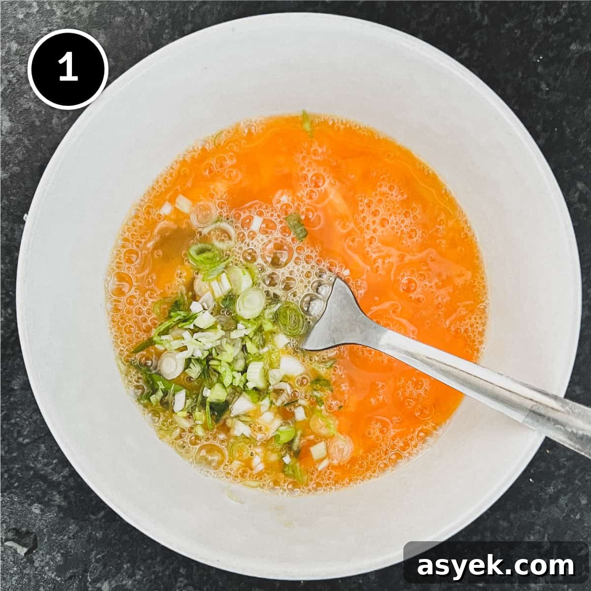 Thai Omelette (Kai Jeow) | cookeatworld.com Beaten eggs in a small bowl with spring onion