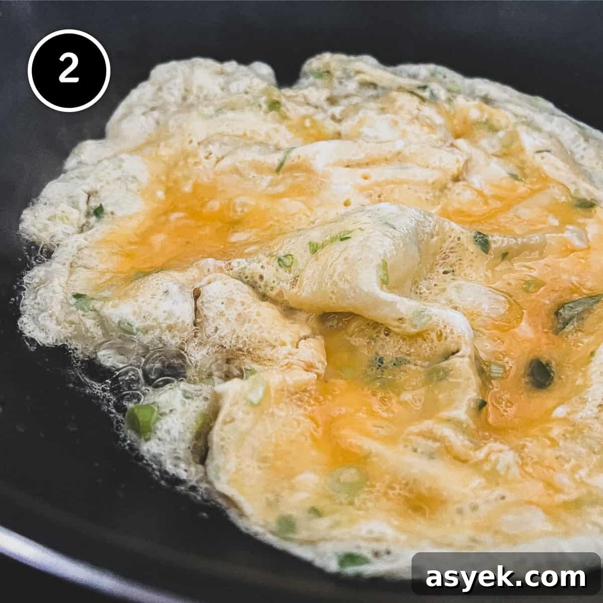 Thai Omelette (Kai Jeow) | cookeatworld.com A Thai omelette frying in a wok
