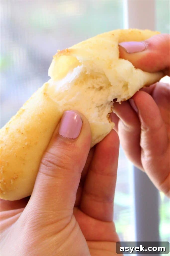 tearing apart breadstick with hands